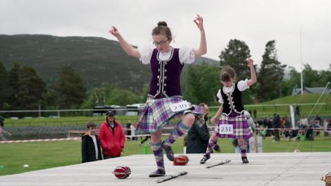 two girls dancing around swords
