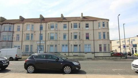 Mulroy's is a three-storey white terraced seafront building.