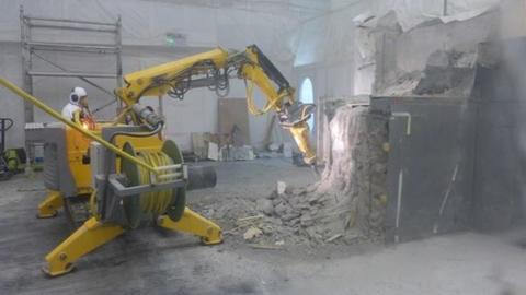 Robotic machine demolishing parts of the interior of a building at Dounreay