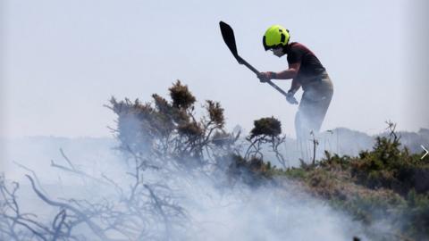Firefighters attend a gorse bush fire, during a heatwave near Zennor, Cornwall, Britain, July 19