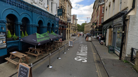 St Nicholas Street in Bristol. There are shops and restaurants lining the street.