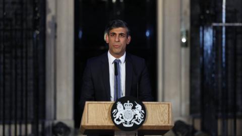Prime Minister Rishi Sunak standing at a lectern outside 10 Downing Street