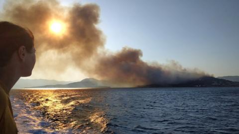 Smoke billows over the sea from a wildfire on Samos island, Greece, 24 August 2019