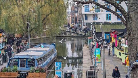 Crowds of people visit the Camden Market area, a collection of interconnected retail markets, commonly known as Camden Market or Camden Lock, in Camden Town, London