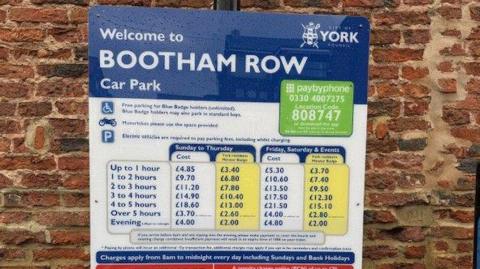A City of York Council car parking charges sign on Bootham Row in York - with prices displayed in both white and yellow.