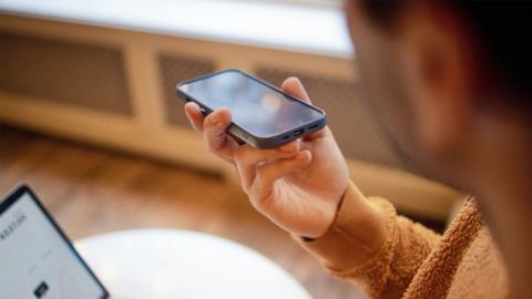 Someone holding their phone and making a voice note.