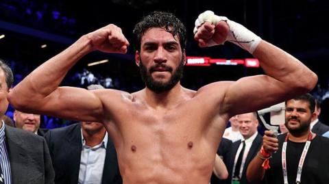 Hamzah Sheeraz flexes his muscles as he celebrates in the ring