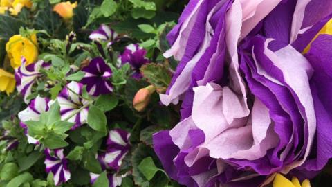 Paper flowers and real flowers side by side