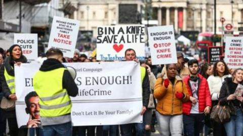 Protesters carrying anti-knife crime placards