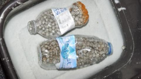Two plastic bottles with tin foil balls and screws in them