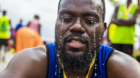 Man with water pouring down his face