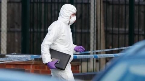 A member of the scientific police walks next to the scene where MP David Amess was stabbed