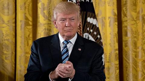 President Donald Trump listens during a swearing in ceremony of White House senior staff in the East Room of the White House