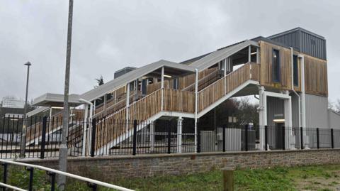 A bridge at a St Erth station in Cornwall allows passengers to get between the platforms. It features a new lift in the main columns and the stairwells have wooden cladding.