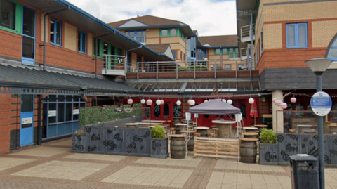 General view of the entrance of the Red By Night club on the Waterfront in Brierley Hill. There's a seating area with small gazebo in front of the building.