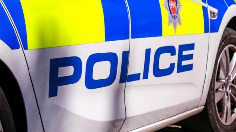 The side of a police vehicle up close. 