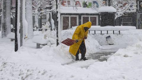 A person with a shovel in deep snow