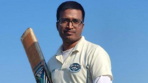 Suffolk cricketer Kishor Kumar Sadhak pictured holding a bat