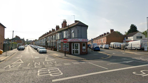 Two terraced streets with cars and cars parked on them 