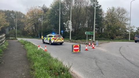 A police car, bollards and a no entry sign at the scene of an accident on the A259 in Sussex.