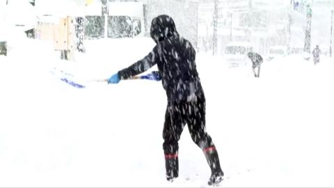 A man shovelling snow in snowfall