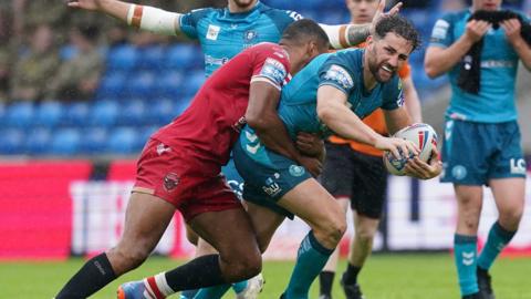 Wigan Warriors' Toby King is tackled by Salford red Devils' Kallum Watkins