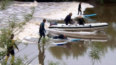 Surfers riding the river Severn bore