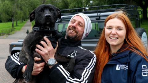 A client with their dog Spotty and a veterinary student