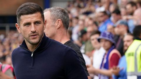 Portsmouth boss John Mousinho leaves the pitch.