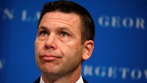 Acting Department of 鶹Լland Security Secretary Kevin McAleenan reacts while protesters interrupt his remarks at the Migration Policy Institute annual Immigration Law and Policy Conference in Washington, October 7, 2019