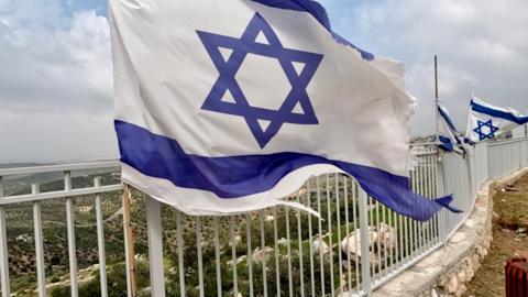 Israeli flag flies at a settlement building site
