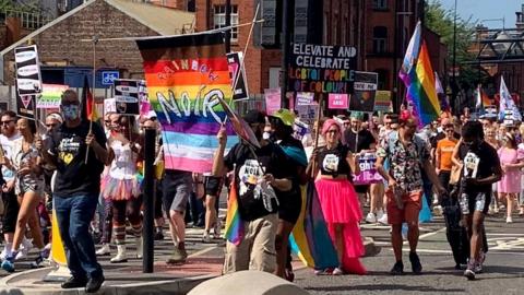 protesters march with flags and placards