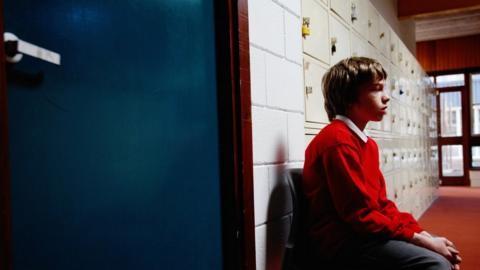 Boy sitting outside class