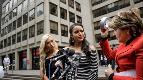 former Houston Texans cheerleaders Hannah Turnbow and Angelina Rose look on as attorney Gloria Allred holds up a roll of duct tape during a news conference