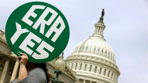 A woman hold up a sign as members of Congress and representatives of women's groups hold a rally to mark the 40th anniversary of congressional passage of the Equal Rights Amendment (ERA) outside the U.S. Capitol March 22, 2012 in Washington, DC