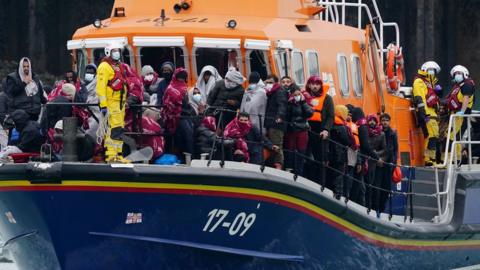 A group of people thought to be migrants are brought into Dover