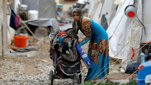 A Syrian refugee mother puts her baby into a stroller in Nizip refugee camp, near the Turkish-Syrian border in Gaziantep province, Turkey, 30 November, 2016.