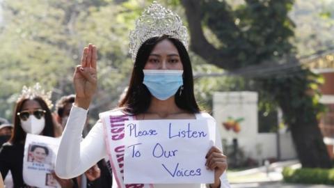 Participants of beauty pageants flash the three-finger salute and hold placards as they march in front of the US Embassy during a protest against the military coup, in Yangon, Myanmar, 10 February 2021