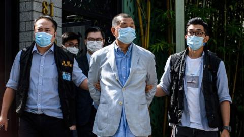 Police lead Hong Kong pro-democracy media mogul Jimmy Lai (C) away from his home