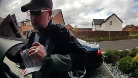 David Wickerson removing a flyer from a letterbox