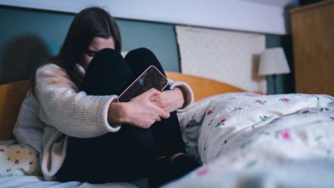 Distressed girl with mobile phone