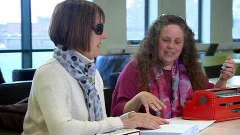 Tracey Martin-Smith helping Annette Peter with braille