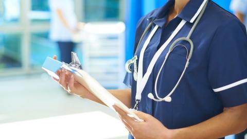 A stock image of a nurse holding a clipboard