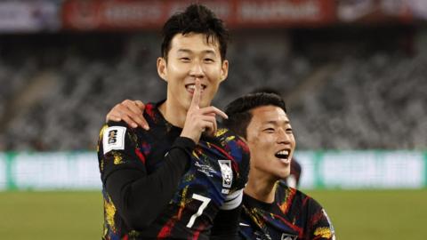 South Korea's Son Heung-min celebrates scoring the first goal against China with Hwang Hee-Chan