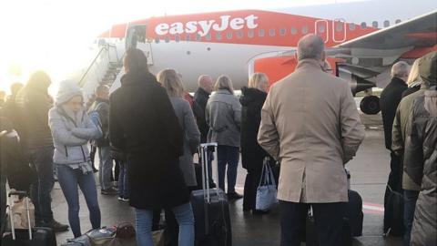 Passengers wait to board a flight in Liverpool after being forced to disembark