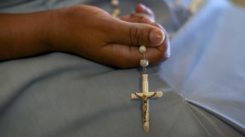 A nun holds a set of rosary beads