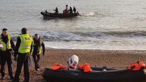 Border force officials by a dinghy