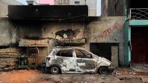 A burnt-out vehicle is pictured following clashes between people supporting and opposing a contentious amendment to India"s citizenship law, in New Delhi on February 26, 2020