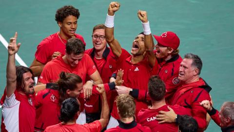 The Canadian team surround Felix Auger-Aliassime after his win clinched the Davis Cup title