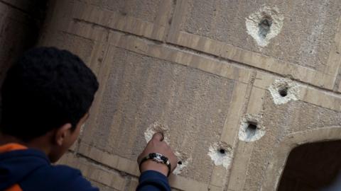 A man fingers bullet holes in a wall outside Mar Mina church following an attack on the church in the district of Helwan, south-eastern Cairo, Egypt, 29 December 2017